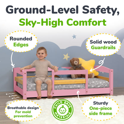 Child sitting on a pink bed with safety features highlighted, including rounded edges and solid wood guardrails.