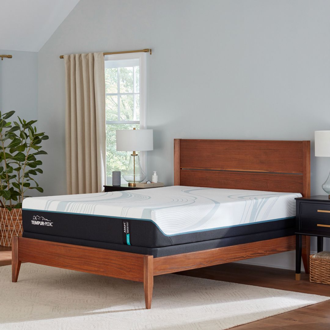 Wooden bed with Tempur-Pedic adapt medium mattress in a bedroom setting