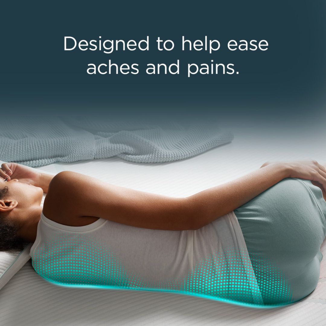 Person lying on a tempur-pedic mattress designed to help ease aches and pains, with a dark blue background.
