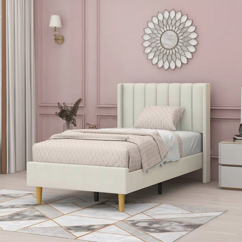 Twin cream upholstered bed in a stylish bedroom with pink walls and decorative elements.