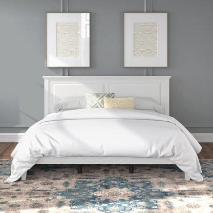 White king size oak bed frame with matching headboard against a gray wall with two framed artworks.