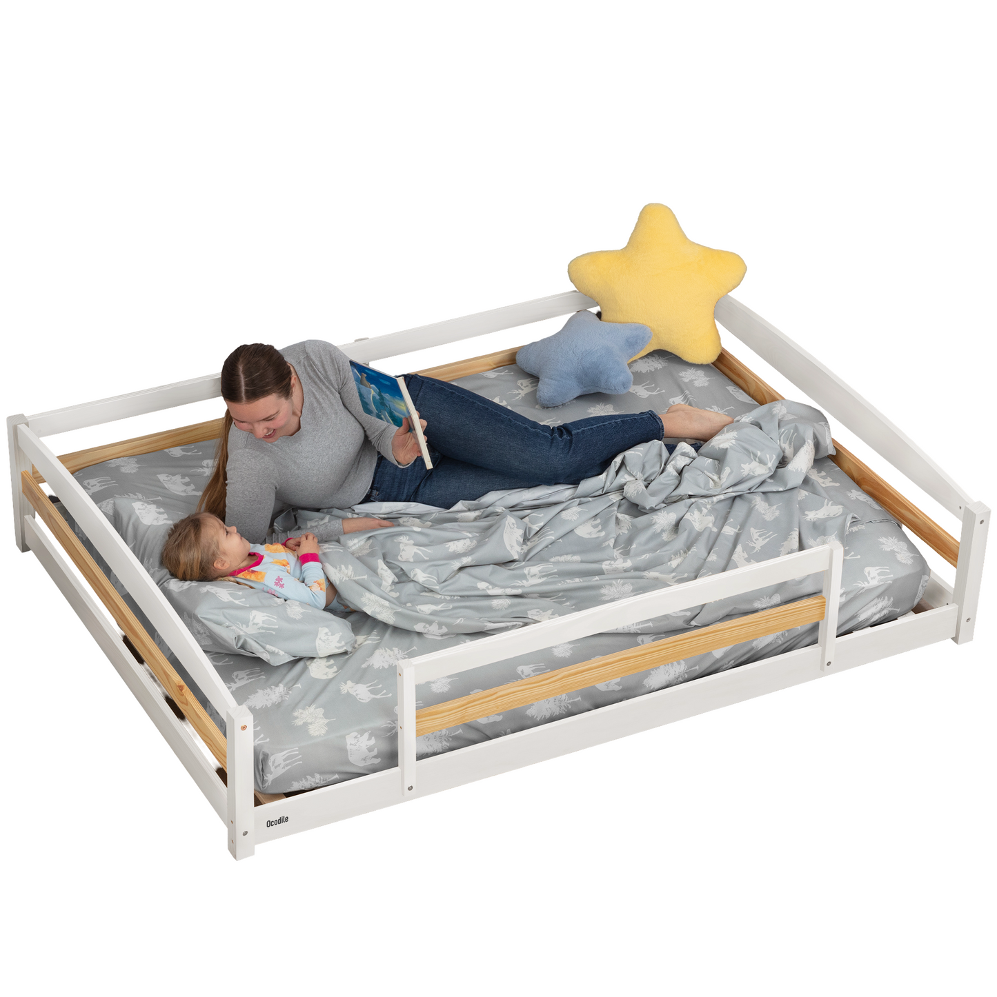 Woman in a full size white montessori bed reading to a child on a large bed with star and cloud pillows.