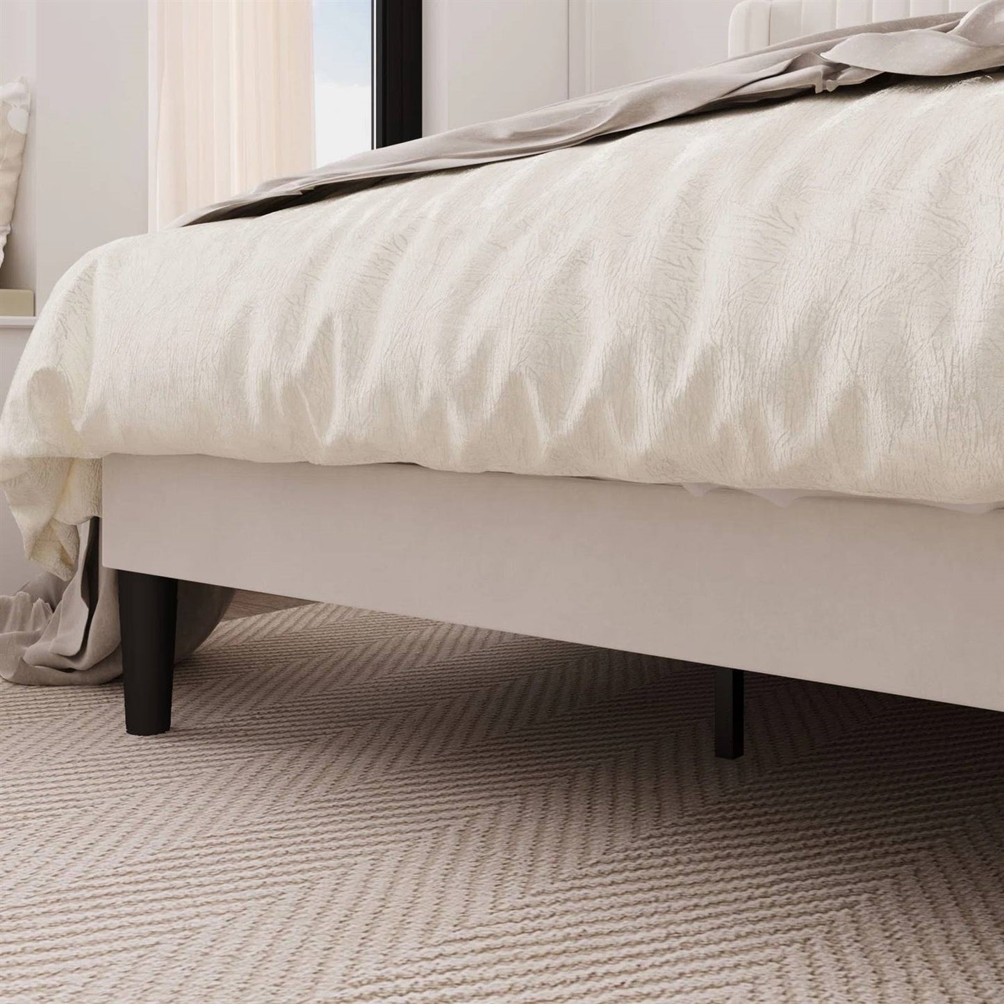 Close-up of a king size white velvet bed with white bedding on a textured carpet