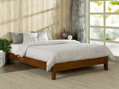 Wooden bed with striped bedding in a room with a window and plant